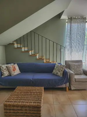 a living room with a blue couch and stairs at Eco Residence in Ribarica