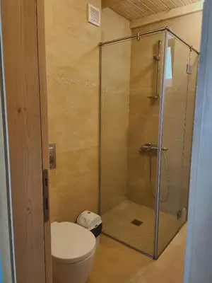 a bathroom with a toilet and a glass shower at Eco Residence in Ribarica