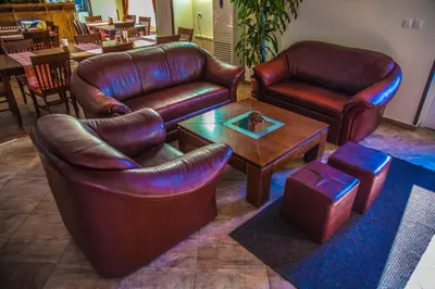 a living room with two leather chairs and a table at Bariakov Family Hotel in Bansko