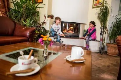 a group of children in a living room with a fireplace at Bariakov Family Hotel in Bansko