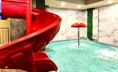 a slide in a swimming pool with a red slide at Hotel Orpheus in Pamporovo