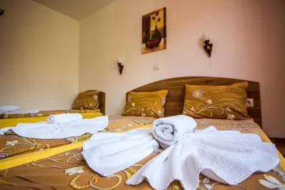 a bedroom with two beds with towels on them at Vien Guest House in Bansko