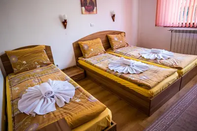 two beds in a small room withskirts at Vien Guest House in Bansko