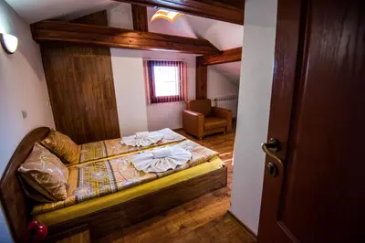 a bedroom with a bed and a chair in a room at Vien Guest House in Bansko