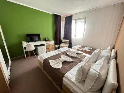a bedroom with a large bed with a green wall at Grami Hotel in Bansko