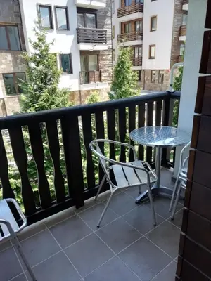 a patio with a table and chairs on a balcony at Fortuna Apartments in Bansko