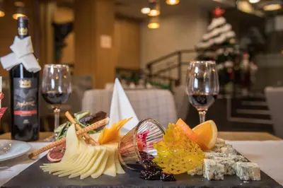 a table with a plate of food and two glasses of wine at St George Ski & Holiday - Half Board & All Inclusive in Bansko