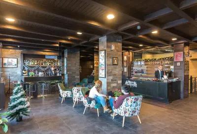a group of people sitting in chairs in a bar at St George Ski & Holiday - Half Board & All Inclusive in Bansko