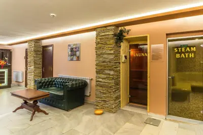 a waiting room with a green couch and a table at Elina Hotel in Pamporovo