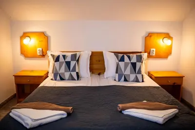 a bedroom with a large bed with two towels on it at Vezyuva House in Bansko