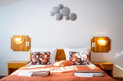 a bedroom with a bed with orange sheets and pillows at Vezyuva House in Bansko