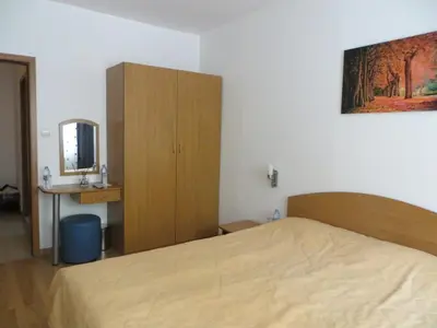 a bedroom with a bed and a cabinet and a mirror at Apartment 