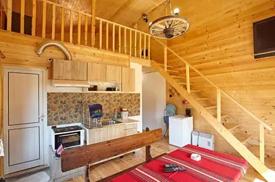 a kitchen with a staircase in a wooden cabin at Guesthouse Vazrozhdenski kashti in Manastir