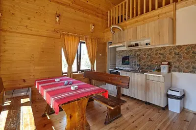 a dining room with a table and a kitchen at Guesthouse Vazrozhdenski kashti in Manastir
