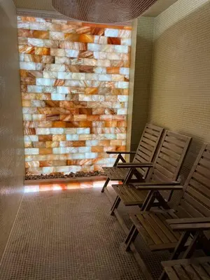 two chairs sitting in front of a stone wall at Hotel Iceberg Bansko in Bansko