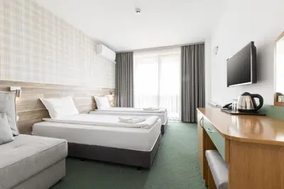 a hotel room with two beds and a couch at Hotel Iceberg Bansko in Bansko