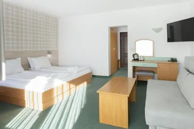 a hotel room with a bed and a couch at Hotel Iceberg Bansko in Bansko