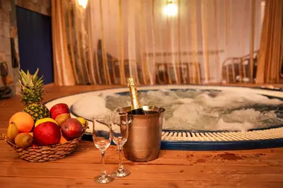 a tub with a bottle of champagne and two wine glasses at Hotel Iceberg Bansko in Bansko