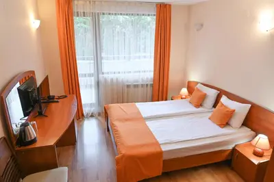 a bedroom with a bed and a tv and a window at Apart Hotel Orbilux in Bansko