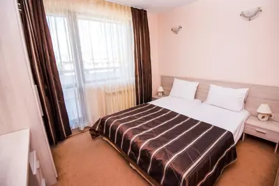 a bedroom with a large bed and a large window at Apart Hotel Orbilux in Bansko