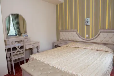 a bedroom with a bed and a desk and a mirror at Hotel Bordo in Plovdiv