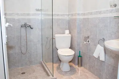 a bathroom with a shower and a toilet and a sink at Hotel Bordo in Plovdiv