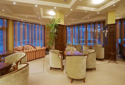 a restaurant with tables and chairs and large windows at Hotel Bordo in Plovdiv