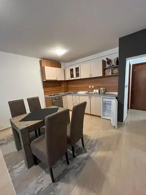 a kitchen with a dining room table and chairs at Monastery 2 Aparthotel in Pamporovo