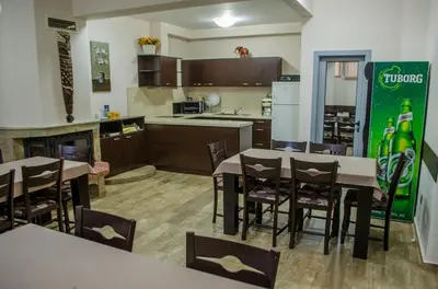 a kitchen and dining room with tables and chairs at Guest House Dinevi in Sapareva Banya