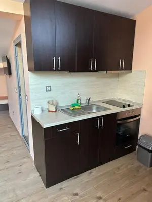 a kitchen with dark brown cabinets and a sink at Guest House Dinevi in Sapareva Banya