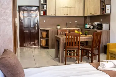 a kitchen with a table and chairs in a room at Luxor Apartment in Velingrad