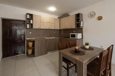 a kitchen with a wooden table and a dining room at Luxor Apartment in Velingrad
