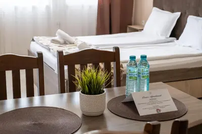 a table with two bottles of water on it with a bed at Luxor Apartment in Velingrad