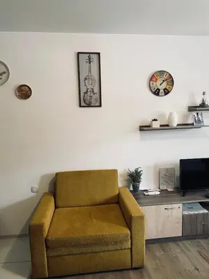 a living room with a chair and a tv at Luxor Apartment in Velingrad