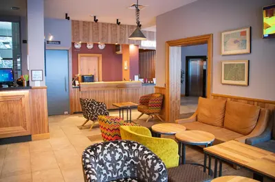 a waiting room with chairs and a couch and tables at Ice Angels Hotel in Borovets