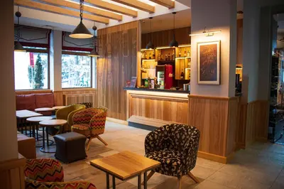 a restaurant with chairs and tables and a bar at Ice Angels Hotel in Borovets