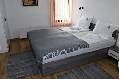 a bedroom with a large bed with a gray blanket at Къща Стария град in Plovdiv