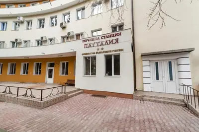 a building with a bench in front of it at Семеен хотел Пауталия in Kyustendil