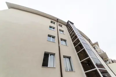 a tall building with windows on the side of it at Семеен хотел Пауталия in Kyustendil