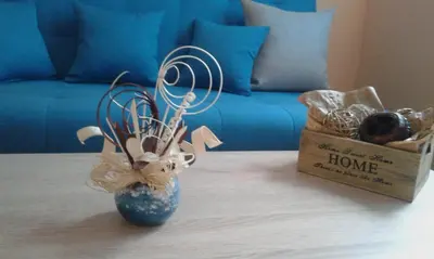 a table with a blue vase and a box of balls at Семеен хотел Пауталия in Kyustendil