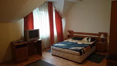 a bedroom with a bed and a tv and a window at TES Royal Plaza Apartments in Borovets