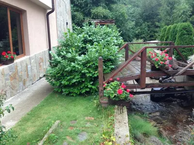 a wooden bridge with flowers in a garden at The Lake Villa in Smolyan