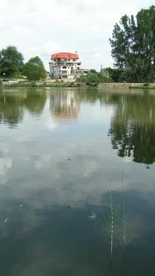 a large body of water with a building in the background at Семеен хотел Кристал in Smolyan
