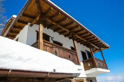 a house in the snow with a balcony at Yancheva Guest House in Delchevo
