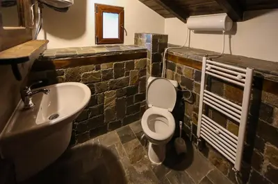 a bathroom with a white toilet and a sink at Yancheva Guest House in Delchevo