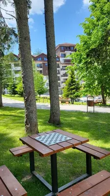 a picnic table in a park with trees at Borovets Gardens Apartments in Borovets