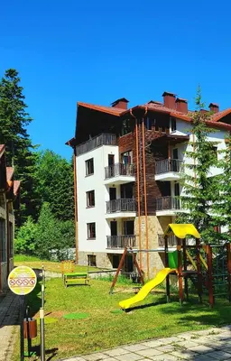 a apartment building with a playground in front of it at Borovets Gardens Apartments in Borovets
