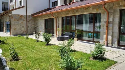 a garden with plants in front of a building at Borovets Gardens Apartments in Borovets