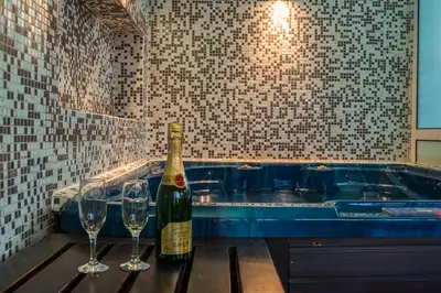 a bottle of wine and two wine glasses on a table at Boutique Guest House IKONOMOV in Bansko