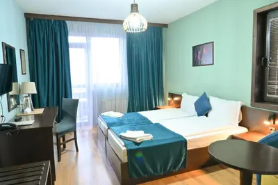 a hotel room with a bed and a table at Hotel Ida in Bansko